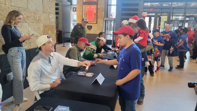 Texas Rangers relief pitcher Josh Sborz signs autographs, along with pitching coach Mike Maddux, pitcher Jon Gray, and bullpen coach Brett Hayes during the club's holiday toy drive on Thursday at Globe Life Field.